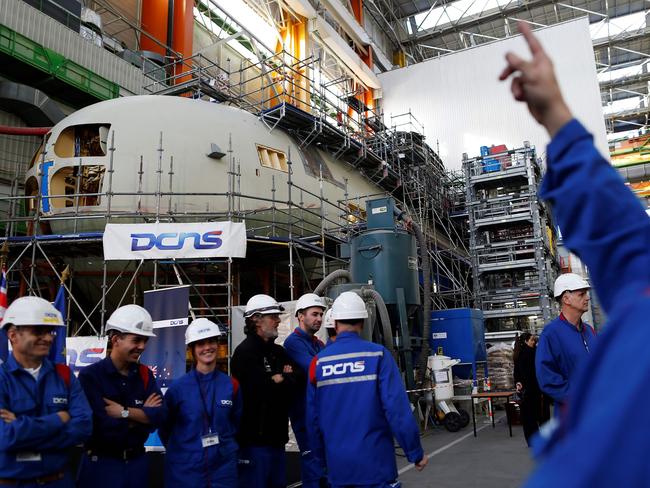 The Cherbourg factory is fitted with a virtual reality unit for submarine design. Pictured, workers in front of a French Submarine that is the basis for 12 New Australian ones. Picture: AFP/Charly Triballeau
