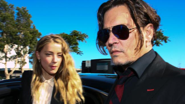 US actor Johnny Depp (R) and his wife Amber Heard arrive at a court in the Gold Coast on April 18, 2016.  Depp and Heard arrived at an Australian court April 18 over Heard's alleged illegal importation of their two Yorkshire terrier dogs Boo and Pistol into the country in a private jet in 2015, as Depp was in Australia for the filming of the latest Pirates of the Carribean movie.    / AFP PHOTO / Patrick HAMILTON