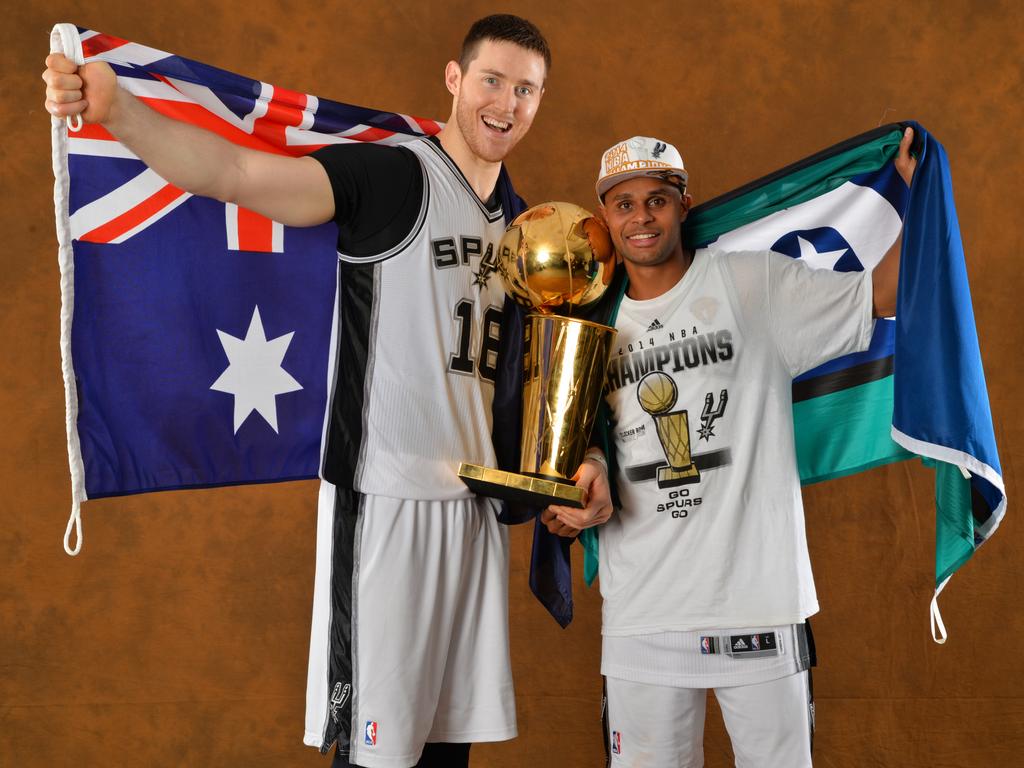 Aron Baynes and Patty Mills with the Larry O’Brien Trophy after winning the NBA championship with San Antonio in 2014. Picture: Jesse D. Garrabrant/NBAE via Getty Images.