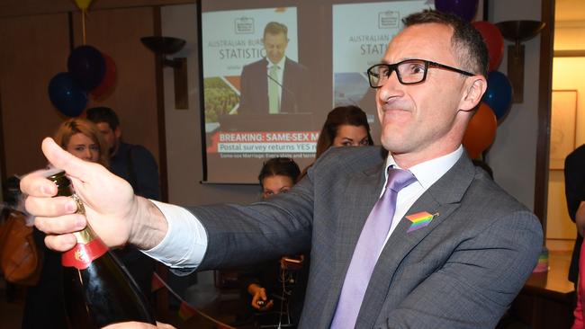 Australian Greens Leader Senator Richard Di Natale pops the cork on a bottle of Champagne as they join Parliamentarians for YES after watching a live broadcast of the announcement of the results of the Marriage Equality survey in Canberra on Wednesday, November 15, 2017. Australians have given same-sex marriage their approval with a 61.6 per cent 'yes' vote in a voluntary survey. (AAP Image/Dean Lewins) NO ARCHIVING