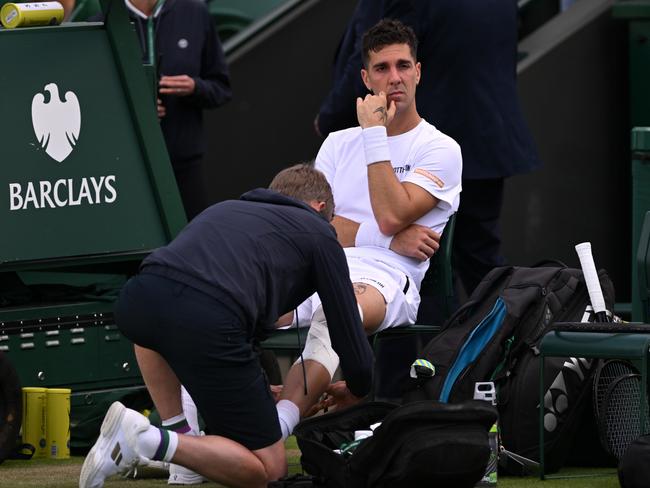 LONDON, ENGLAND - JULY 04: Thanasi Kokkinakis of Australia receives medical treatment before retiring injured during in his Gentlemen's Singles second round match against Lucas Pouille of France during day four of The Championships Wimbledon 2024 at All England Lawn Tennis and Croquet Club on July 04, 2024 in London, England. (Photo by Mike Hewitt/Getty Images)