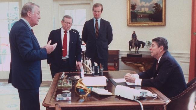 Ronald Reagan is briefed by Ed Meese. Chief of Staff Howard Baker, centre, and his aide Arthur Culvahouse, look on. Picture: Getty Images