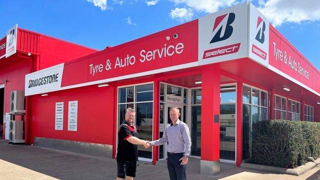 Bridgestone Select Deeragun franchisee Brynn Greenhill is congratulated by Neville Smith of commercial real estate agents Burgess Rawson after expanding into the spacious new premises on North Vickers Road in Condon. Picture: Supplied