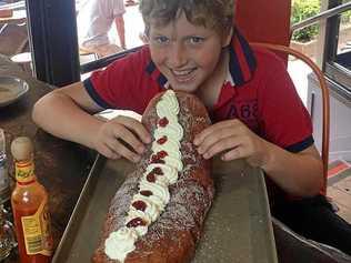 David takes on the challenge, but is bested by the huge, cream-filled doughnut. Picture: Kenilworth Bakery