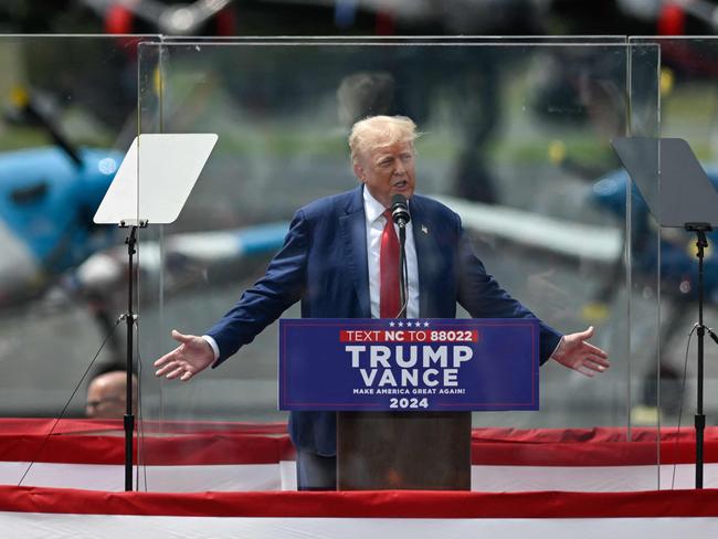 Former US President and Republican presidential candidate Donald Trump speaks behind bulletproof glass during a campaign rally at the North Carolina Aviation Museum & Hall of Fame in Asheboro, North Carolina, August 21, 2024. (Photo by Peter Zay / AFP)