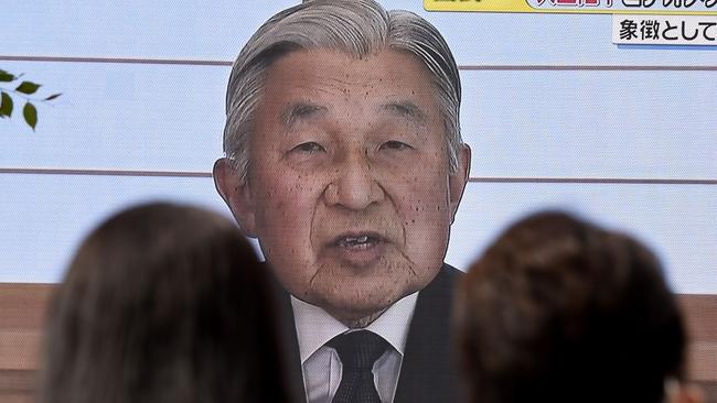 People look at a big video screen on the street as a speech by Japanese Emperor Akihito to the nation is televised in Tokyo on August 8, 2016. Picture: AFP.
