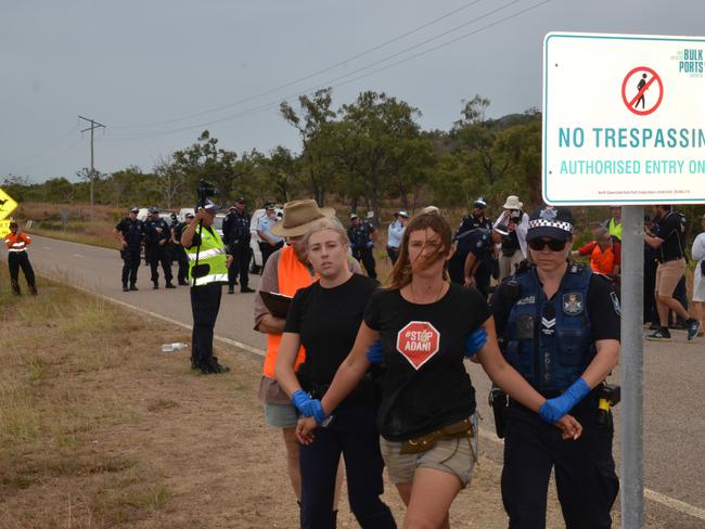 Police lead an arrested protester away to the waiting paddy wagons at the Abbot Point access road during one of many protests against the mine. Picture: John Andersen