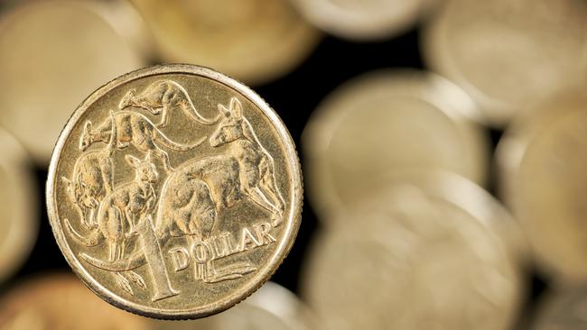 Australian one dollar coin over blurred golden background.