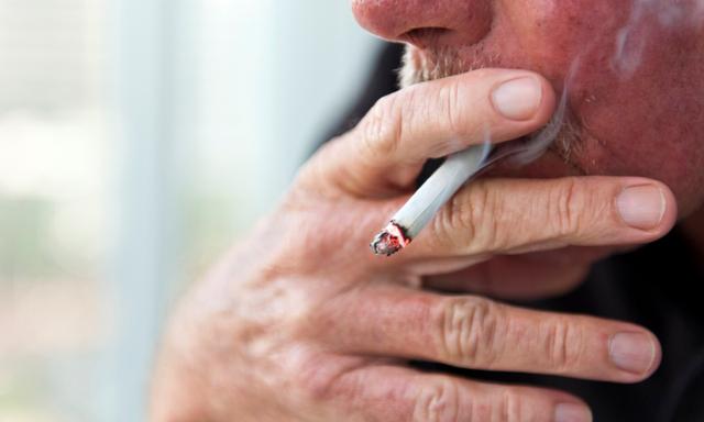 Caucasian old man smoking a cigarette