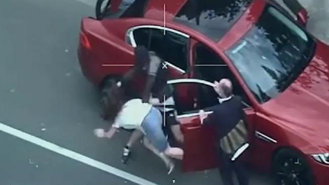 Police helicopter video footage from a police chase shows a man grabbing a woman by her hair and throwing her to the ground to steal her car.