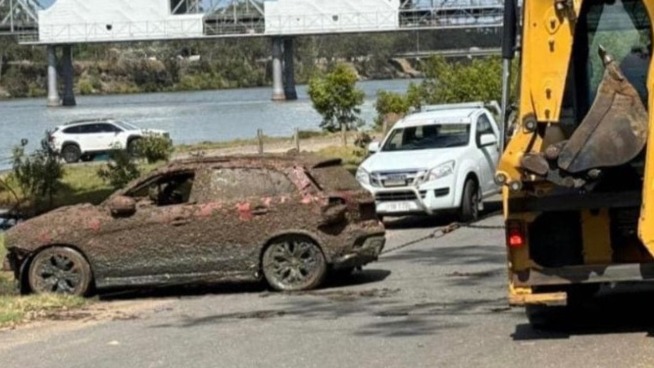 A small SUV is pulled out of the Burnett River under the inner city's main traffic bridge on October 16, 2024.