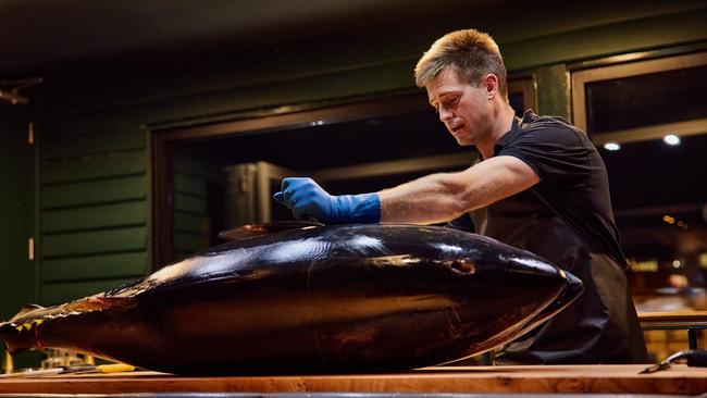 Jock Mure carves up an 80kg Southern bluefin tuna at Mures Upper Deck to prepare the tuna for a special four-course degustation dinner _ during a special carving ceremony. Picture SUPPLIED by Mures restaurant MUST CREDIT Samuel Shelley