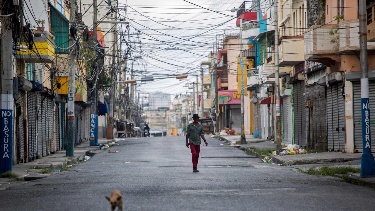 A man and a dog walk along an empty street in Santo Domingo in the Dominican Republic on Easter Sunday. Picture: Erika Santelices/AFP