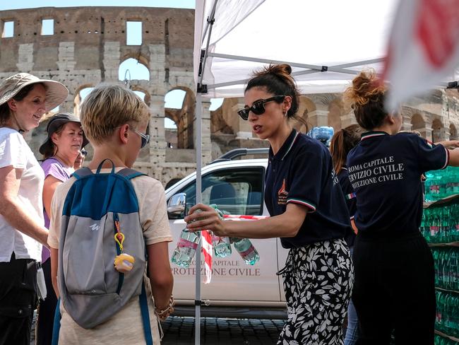 Members of the Italian Civil Protection (Protezione Civile) distribute water bottles to people and tourists in front of the Ancient Colosseum, in central Rome. Picture: Andreas Solaro