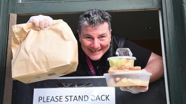 St Mary's House of Welcome community support worker Brian Reilly handing out food parcels through the charity’s window on Brunswick St. Picture: Josie Hayden