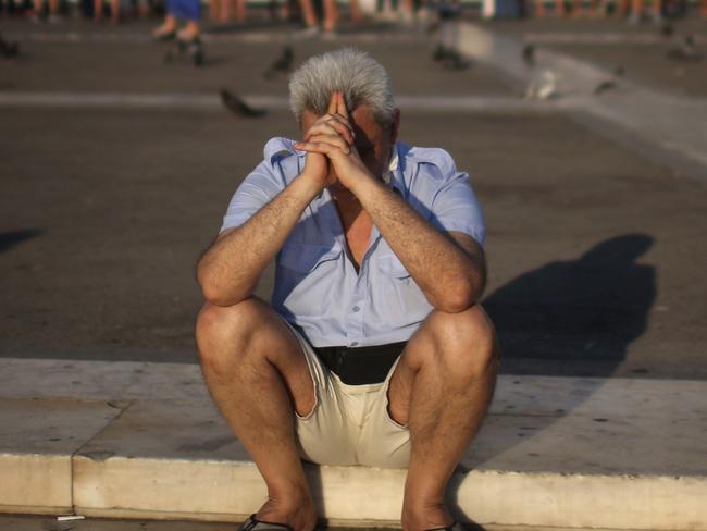 ATHENS, GREECE - JULY 13: A man sits alone with his thoughts as protesters gather outside the Greek parliament to demonstrate against austerity after an agreement for a third bailout with eurozone leaders on July 13, 2015 in Athens, Greece. The bailout is conditional on Greece passing agreed reforms in parliament by Wednesday which includes streamlining pensions and rasing more raise tax revenue. (Photo by Christopher Furlong/Getty Images)