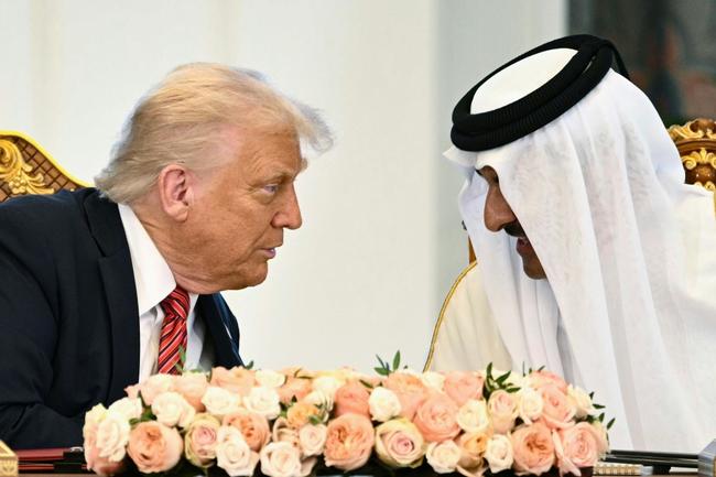 Qatar's Emir Sheikh Tamim bin Hamad al-Thani (R) and US President Donald Trump speak to each other at the Royal Palace in Doha on May 14, 2025
