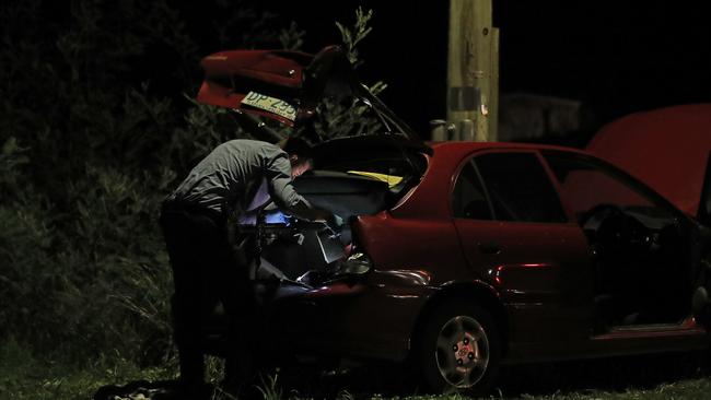 Tasmanian police inspect a  car out the front of a Magra property on Back River Road.  Picture: Zak Simmonds