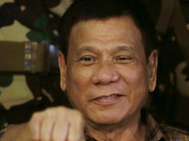 FILE - In this Aug. 25, 2016, file photo, Philippine President Rodrigo Duterte gestures with a fist bump during his visit to the Philippine Army's Camp Mateo Capinpin at Tanay township, Rizal province east of Manila, Philippines. The Philippine president has apologized to Jews worldwide after his remarks that drew comparisons between his bloody anti-drug war and Hitler and the Holocaust sparked shock and outrage. (AP Photo/Bullit Marquez, File)