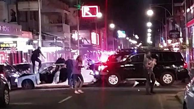 Police whisk a woman and her children away from a car in Hindley St after shooting driver Damien Keith Hall last month, who had allegedly kidnapped them and pointed a gun at a toddler. Picture: Nine News