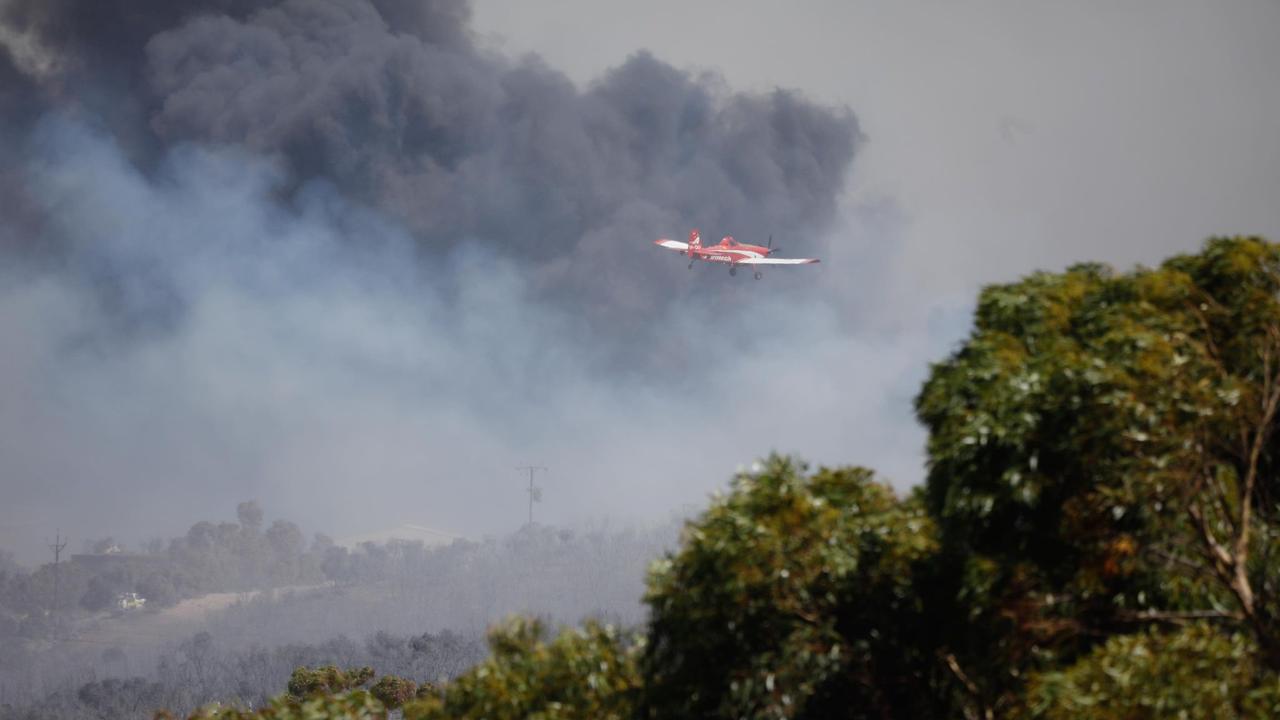 Smoke rises over Port Lincoln as a plane looks for the extent of the fire. Picture: Robert Lang