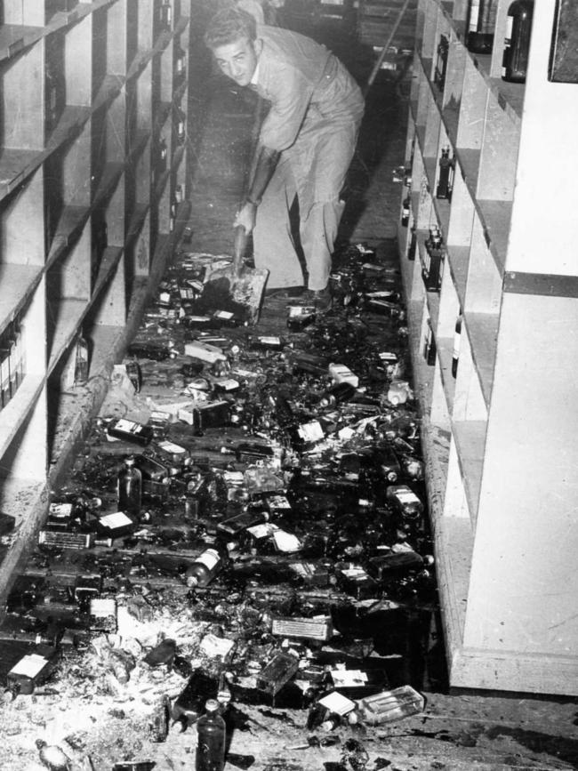 An Adelaide shopkeeper cleans up bottles broken in the 1954 earthquake.