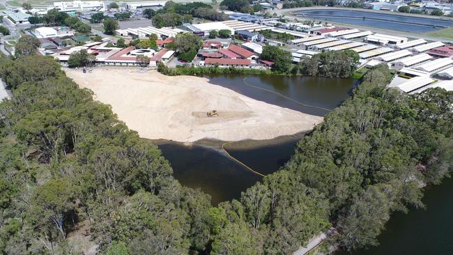 Workers move earth at Black Swan Lake at Bundall, which has almost been filled in. Picture Glenn Hampson