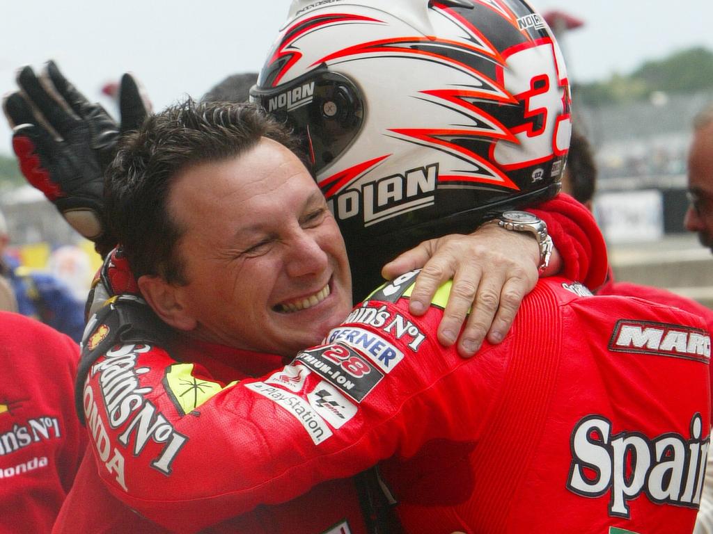 Fausto Gresini (left) celebrates his team’s win at the French MotoGP in 2006. (Photo by JEAN-FRANCOIS MONIER / AFP)