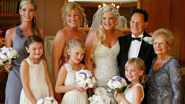 The bride and groom with maid of honour Katie Eagle (back left), mother of the bride Mariela Gordon, flower girls (left to right) Kelsey, Aislyn and Alexis and mother of the groom Esther Edelsten (far right). Picture: Great Expectations Foundation Ltd/Getty Images