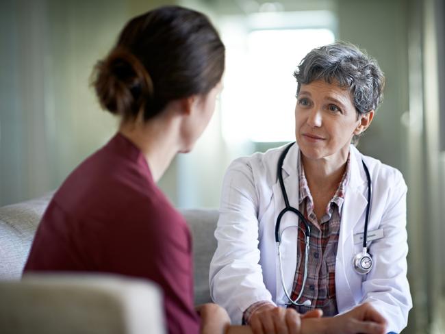 Shot of a compassionate doctor comforting a young woman in a hospital waiting room; fear health scare generic