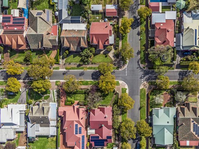 Aerial view of leafy eastern suburban houses on 4-way cross road intersection in Adelaide, South Australia: directly above, rooftop solar, trees. Housing property generic