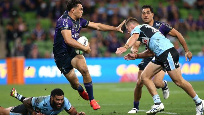 Xavier Coates fends off a Cronulla tackler.