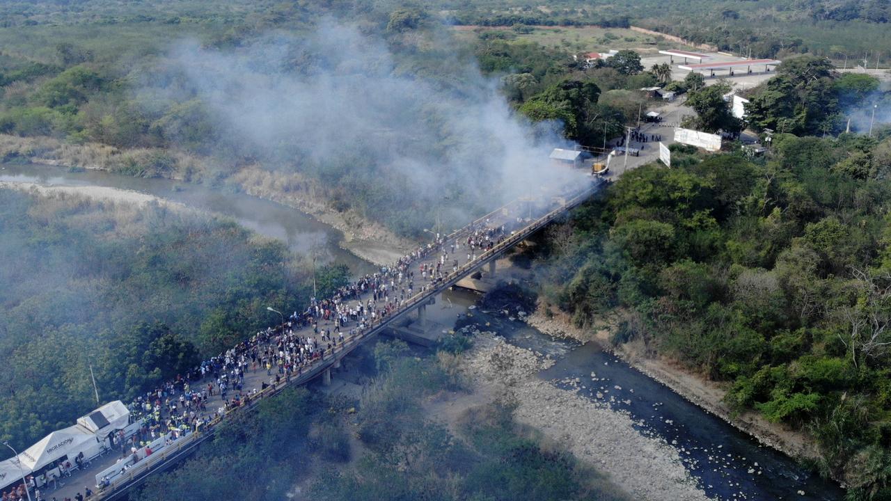 Smoke billows from trucks carrying humanitarian aid that were set ablaze on the Francisco de Paula Santander International Bridge between Cucuta in Colombia and Urena.