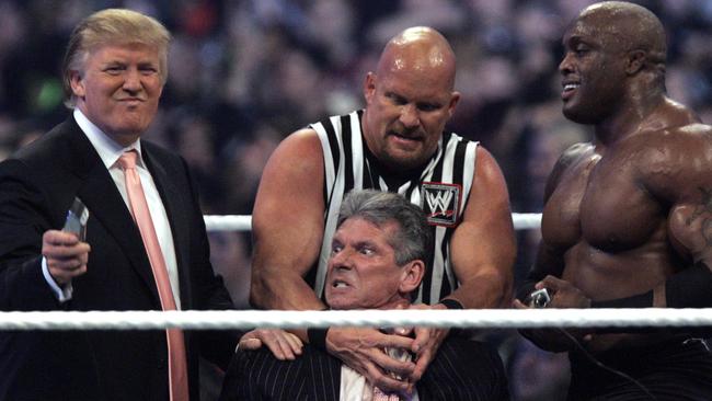 WWE chairman Vince McMahon (centre) held by wrestler 'Stone Cold' Steve Austin, prepares to have his hair cut off by Donald Trump in 2007. Picture: supplied