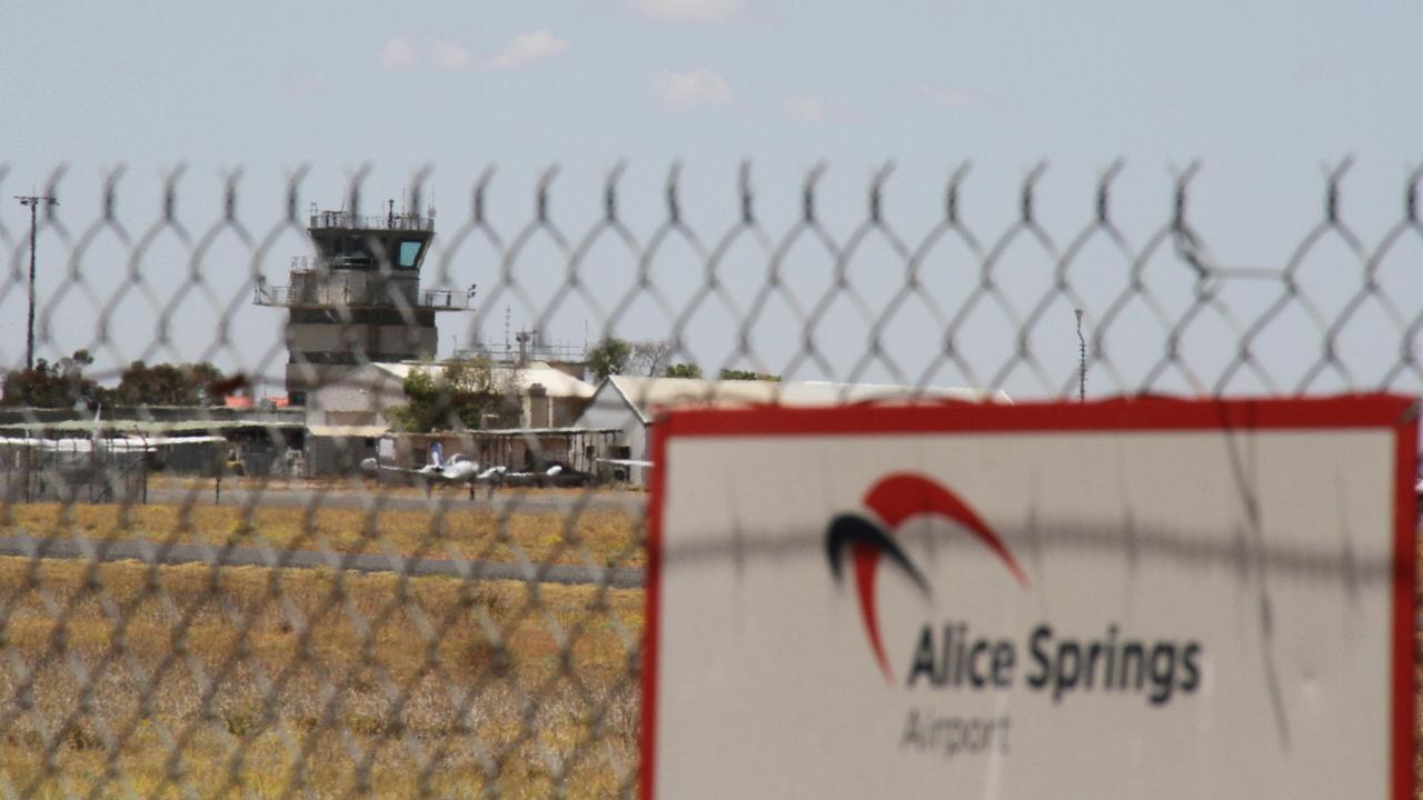 The fence prohibiting access to the Alice Springs Airport runway, with the Alice Springs Airport control tower in the background. Picture: Gera Kazakov