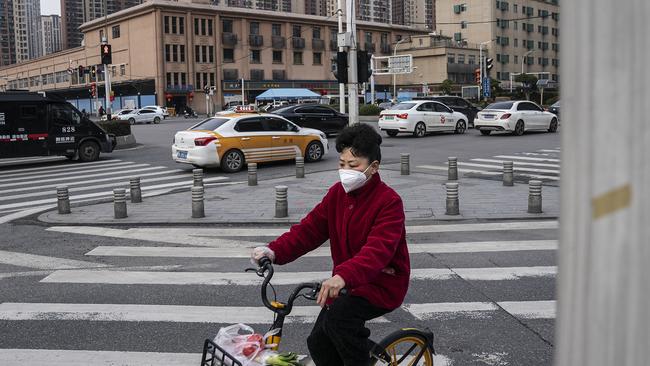 Resident wear a mask while ride through in front of a closed of Huanan seafood market on February 9, 2021 in Wuhan, Hubei Province, China. Picture: Getty Images