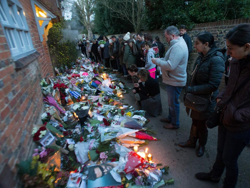 People gather outside the home of British singer George Michael where tributes of flowers, messages and candles have been piled in the village of Goring, southern England. Picture: AFP