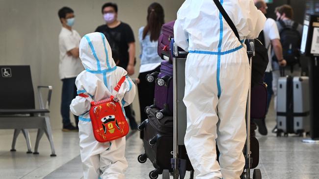 International travellers wearing personal protective equipment (PPE) arrive at Melbourne's Tullamarine Airport. Picture: AFP