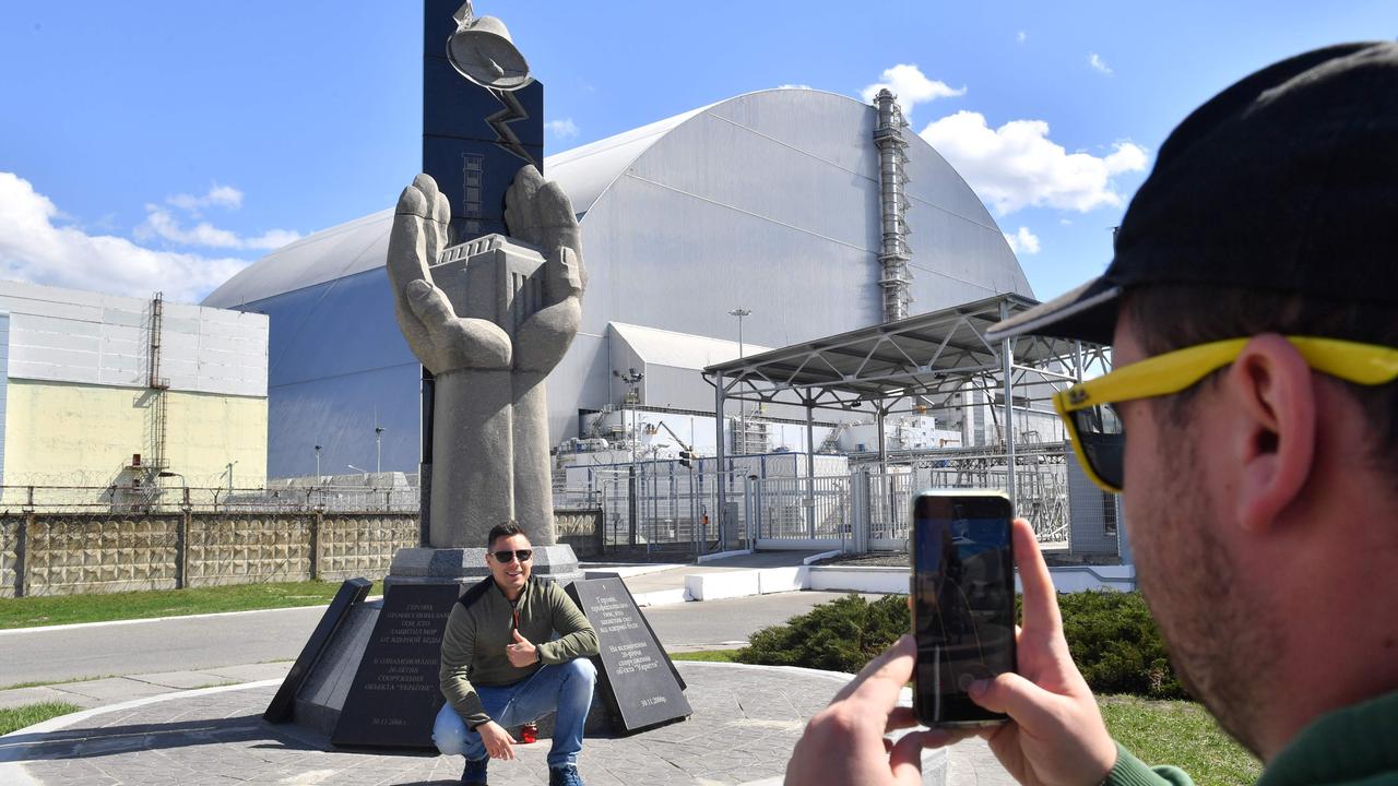 Tourists take pictures at Chernobyl's New 108-metre Safe Confinement covering the 4th block of Chernobyl Nuclear power plant during their tour to the exclusion zone last year. Picture: Sergei Supinsky/AFP