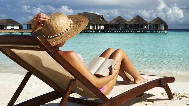 Young woman reading a book at beach