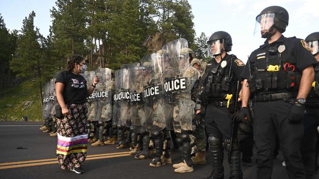 A person faces a row of police as activists and members of different tribes block the road to Mount Rushmore. Picture: AFP