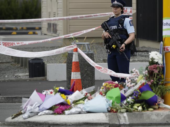 Police stand by a collection of flowers near the Linwood Mosque in Christchurch. Picture: AP