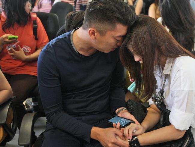 Relatives of passengers of AirAsia flight QZ8501 comfort each other at Juanda International Airport in Surabaya, Indonesia.