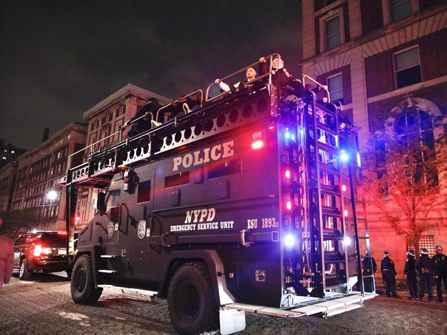 NYPD officers in riot gear arrive at Columbia University, where pro-Palestinian students are barricaded inside a building and have set up an encampment, in New York City on April 30, 2024. Columbia University normally teems with students, but a "Free Palestine" banner now hangs from a building where young protesters have barricaded themselves and the few wandering through campus generally appear tense. Students here were among the first to embrace the pro-Palestinian campus encampment movement, which has spread to a number of universities across the United States. (Photo by Kena BETANCUR / AFP)