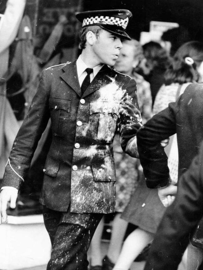 A policeman becomes a victim of a flour bomb as he tries to stop a Prosh student entering Rundle Street on Prosh Day, 1975.