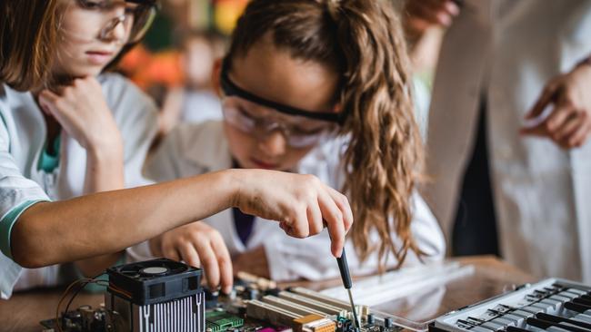 School students repair a motherboard in the classroom.