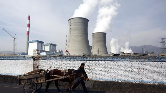 The Bank of China is to stop funding coal-fired power plants offshore. Above, a farmer leads a cart past cooling towers of a coal-fired plant in Datong County, China. Picture: China Photos/Getty Images