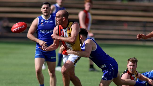 Goodwood Saints star George Thring handballs out of a tackle during the Adelaide Footy League division one semi final against St Peter's Old Collegians. Picture: Kelly Barnes