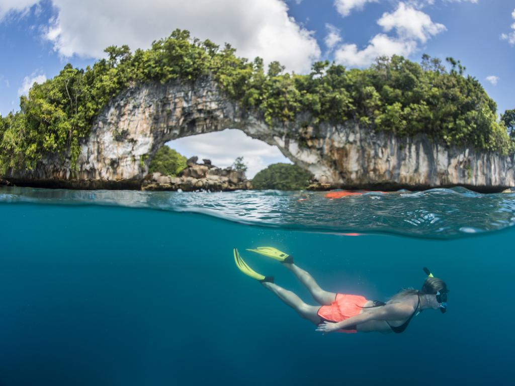 A woman dives off the famous Rock Islands Arch, Palau — Micronesia. Picture: iStock