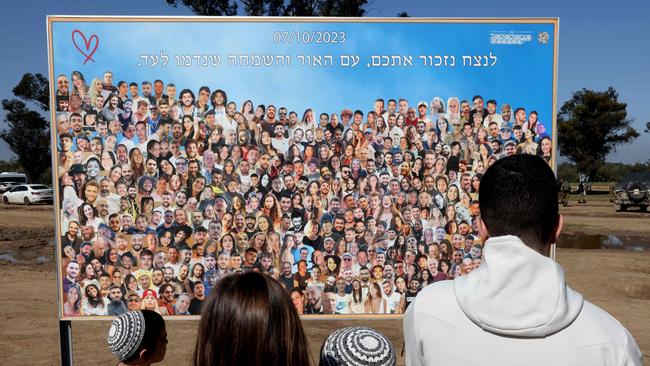 People gaze at a poster bearing pictures of youths taken captive or killed by Hamas militants during the attack on revellers attending the Supernova music festival on October 7. Picture: AFP.